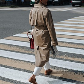 Femme portant un imperméable qui traverse un passage piéton